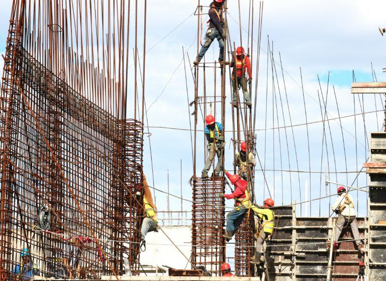Construction workers assembling rebar on a building site.
